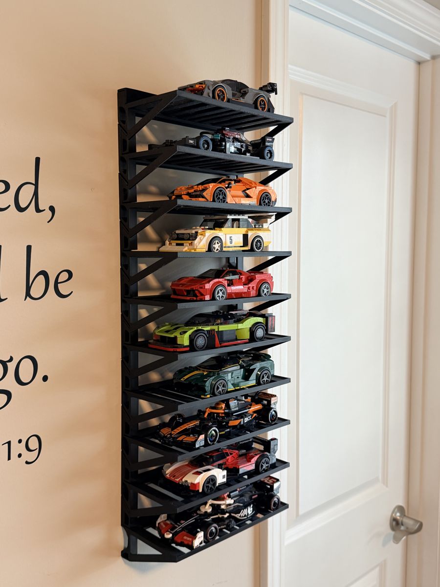 Black 3D-printed wall-mounted rack with multiple shelves holding Lego Speed Champions model cars